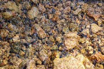 Stones lie under flowing water.