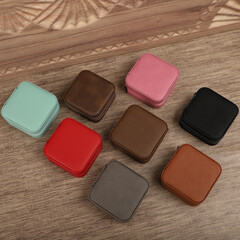 Diffirent colors leather jewelry box. Concept shot, top view. Custom background jewelry box view. Jewelry box and accessories. Wooden background.