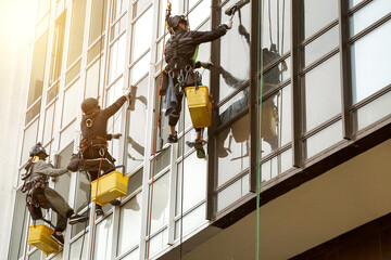 Industrial mountaineering workers hangs over residential facade building