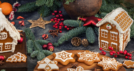 Decorated gingerbread house christmas cookies on dark table