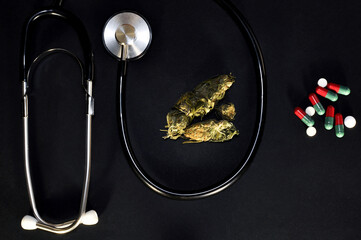 cannabis on a black background. Nearby is a device for measuring cardiovascular pressure, tonometer and pills, Medical cannabis against pills and chemistry