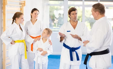 Zelfklevend Fotobehang Family in kimono and colored belts discusses and communicates with trainer after martial art training © JackF