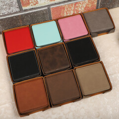 Leather table mats in different colors. Concept shot, top view. Custom background view of leather table coaster. Stitched and leather table coaster