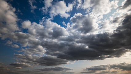 beautiful blue sky with dark dramatic cumulus clouds and sunlight for abstract background