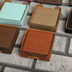 Leather table mats in different colors. Concept shot, top view. Custom background view of leather table coaster. Stitched and leather table coaster