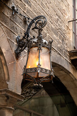 Fototapeta na wymiar Historic wrought iron lantern with glass housing on an architecturally charming building