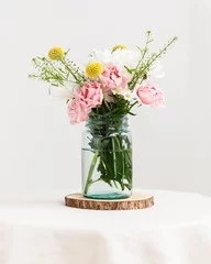Fotobehang Glass mason jar with fresh wildflowers inside on table © Deidre