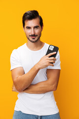 Smiling man communication phone happy studio portrait phone technology mobile message copy space yellow cyberspace smartphone