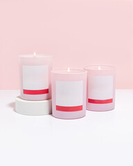 Three pink candle with blank labels on pink background