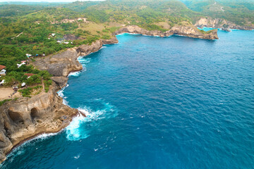Fototapeta na wymiar Cinematic aerial landscape shots of the beautiful island of Nusa Penida. Huge cliffs by the shoreline and hidden dream beaches with clear water.