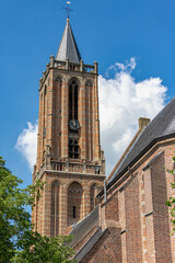 A clock tower building of the Andrieskerk under blue sky, Protestant church in the Dutch village of Amerongen, A town in the municipality of Utrechtse Heuvelrug in the province of Utrecht, Netherlands