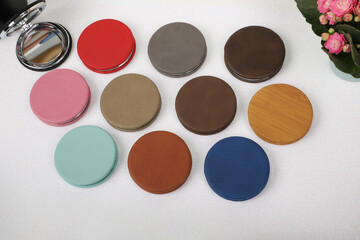 Leather Round pocket makeup mirror in different colors. Concept shot, top view. Custom background, pocket makeup mirror. Travel pocket mirror, free space for text.