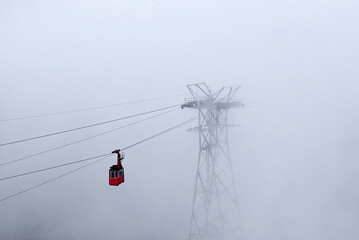 Cable car travelling through dense fog in the Carpathian mountains towards Balea lake.