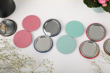 Leather Round pocket makeup mirror in teal and pink colors. Concept shot, top view. Custom background, pocket makeup mirror. Travel pocket mirror, free space for text.