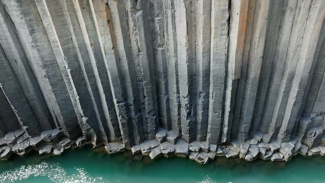 Canyon of magnificent basalt columns, high cliff with bright turquoise river, in North East Iceland, aerial shot. Studlagil, nature beauty concept.