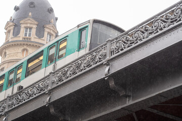 Paris city metro express of line 6 on the Bir Hakeim bridge in the rain