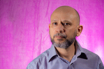 Bald, bearded man looking at camera