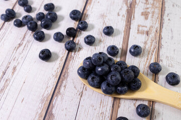 Fresh sweet blueberry fruit in wooden spoon. Dessert healthy food. Group of ripe blue juicy organic berries.