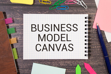 Business Model Canvas. Paper ship and sheet on a gray background. - obrazy, fototapety, plakaty