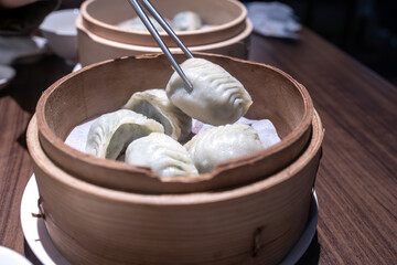 Fototapeta na wymiar Chinese steamed dumplings in bamboo steamer, close up