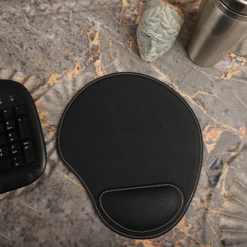 Leather mousepads in black colors. Concept shot, top view. Custom background, leather mousepad. Free space for text.