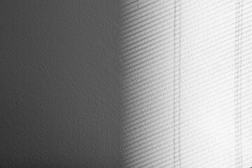 Light and shadow from window on white wall, space for text