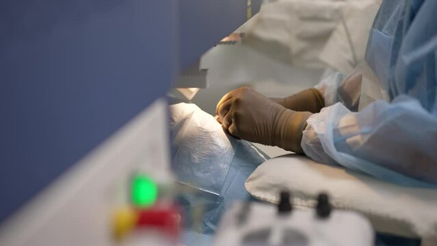 Surgeon's hands in gloves performing laser vision correction, eye surgery. Vision correction procedure, doctor's hands in gloves, close-up. Cataract surgery close up.