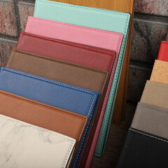 Leather portfolio. Concept shot, top view, portfolio in different colors and leather pen. Custom background flap portfolio view. Portfolio and accessories.