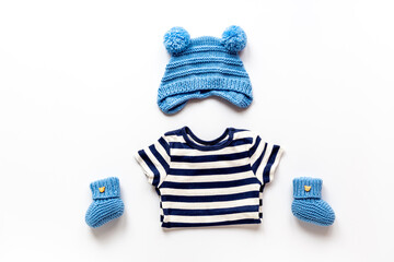Set of baby boy dress - blue bodysuit with knitted hat and boots, top view. Kids clothing flat lay