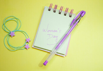 Dairy with message for Women's Day . Decoration of purple stars . Yellow background