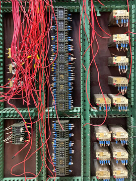 an old machine electrical cabinet with old electrical components, contactors with red cut wires and red cut wires, vintage technology, vertical