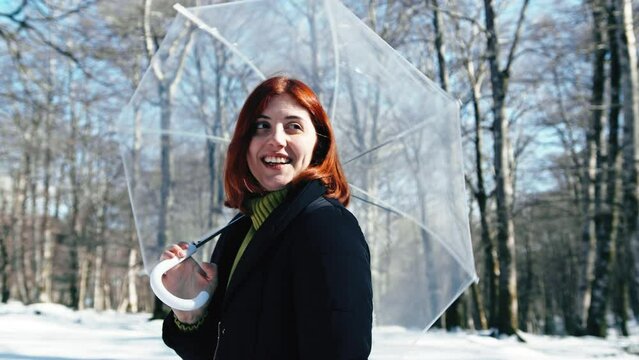 Lady with umbrella in the snowy forest 