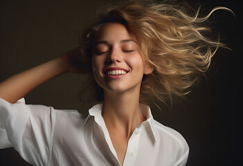 Joyful young blond woman having fun, dancing with happy smiling face and relaxed emotion