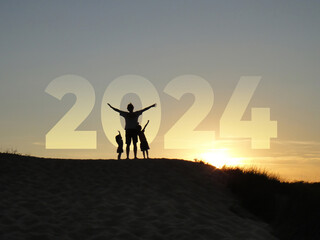 Happy new year 2024! Happy family silhouette on the beach in front of a sunset.