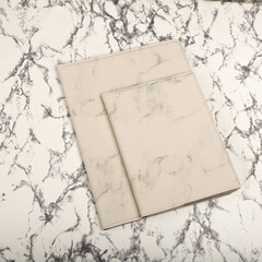 Leather portfolio. Concept shot, top view, portfolio in white marble colors and leather pen. Custom background flap portfolio view. Portfolio and accessories.