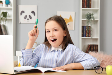 Cute little girl doing lessons at home