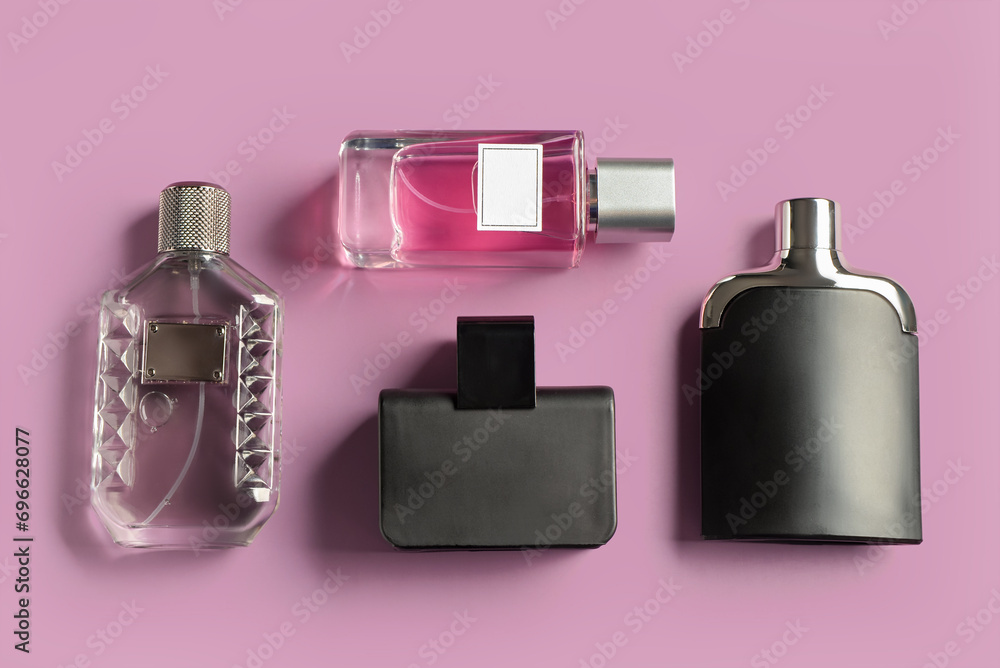 Wall mural bottles of luxury perfume on lilac background