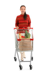 Young Asian woman with shopping cart and bags full of fresh food isolated on white background