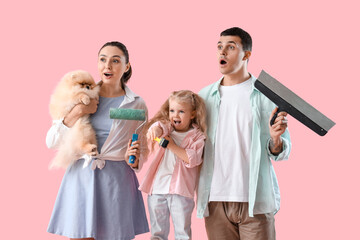 Happy family with repair materials on pink background