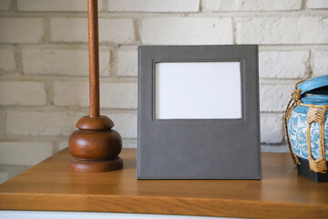 Leather photo frame in gray colors. Concept shot. Custom background, Creative composition of modern living room interior. Free space for text and picture or photograph . Stylish accessory for home.