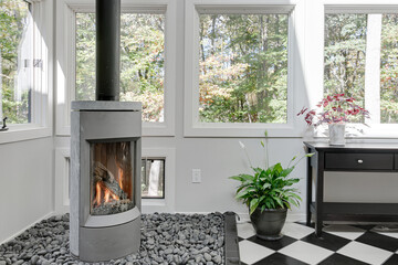 Contemporary Living Room with Standalone Glass Fireplace and Pebble Bed by Large Windows Overlooking Trees
