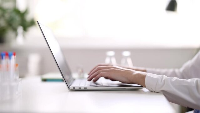 Doctor sitting at the table and typing on laptop. Concept of health and medical care.