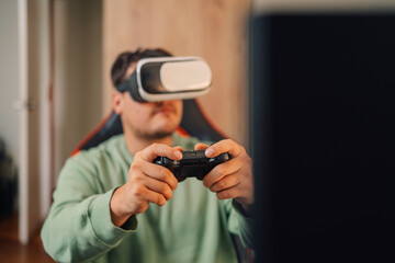 Gamer facing the computer using Virtual reality googles to play - obrazy, fototapety, plakaty