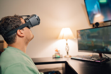 Gamer using virtual reality goggles playing at home