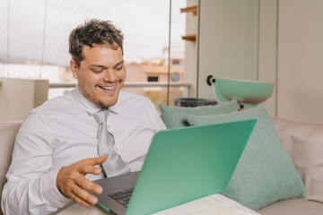 Happy businessman working from home sitting on the sofa