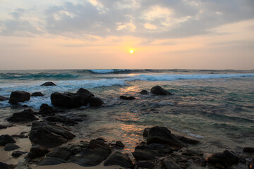 The sun setting into the sea at Delawella beach, Sri Lanka. Golden light