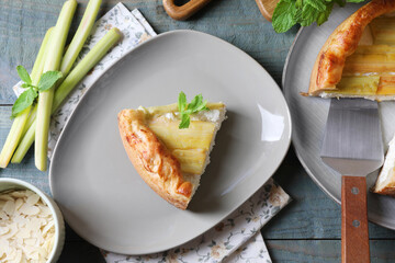 Freshly baked rhubarb pie and stalks on grey wooden table, flat lay