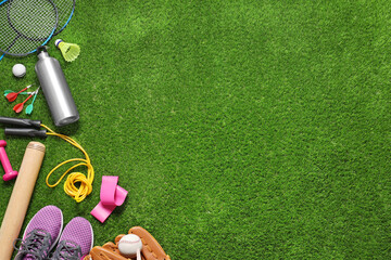 Different sport tools on green grass, flat lay. Space for text