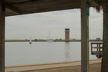 View south out wood pavilion at Demens Landing Park. Through wood rectangles out to airport tower...