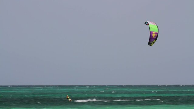 Majestic wide, pan shot of kite surfer in beautiful ocean